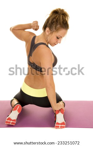 A woman on her knees stretching over her heels.
