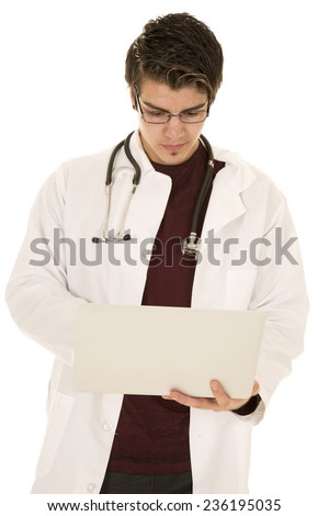 a doctor looking down at his laptop with his stethoscope around his neck.