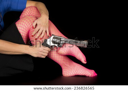 A woman\'s legs in her bright pink fishnets holding onto her pistol