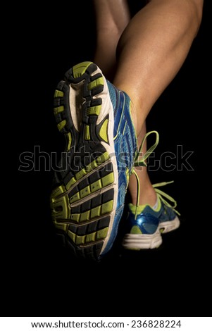 A close up of a woman\'s legs running on black.