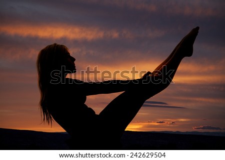 a silhouette of a woman doing a crunch with her body in a v shape.