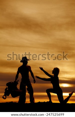 A silhouette of a woman on one knee reach both hands out