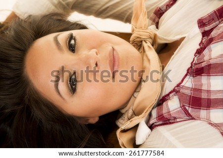 A close up of a woman in her western wear with a sensual expression on her face.
