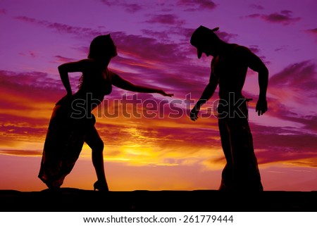A silhouette of a woman in her sexy clothing reaching out to her cowboy.