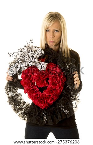 a woman holding on to her heart wreath with a sad expression on her face.