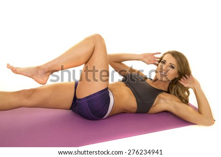 A fit woman doing some crunches with a smile on her face.