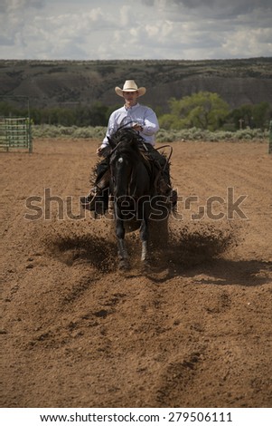 a front view of a cowboy on his horse kicking up dirt.