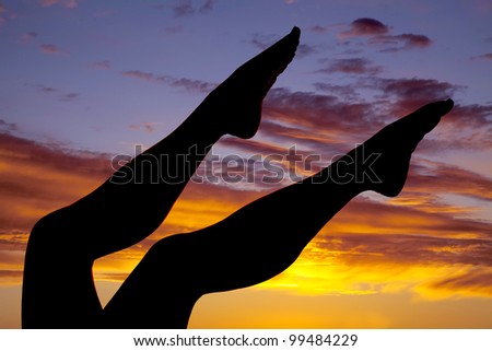 a silhouette of a woman\'s legs in a beautiful sunset.