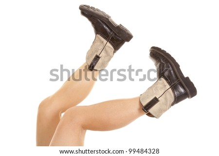 A woman\'s legs up in the air showing off her cowboy boots.