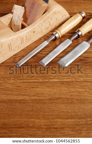Chisel, mallet and wooden plane on a workbench in the carpenter\'s shop.