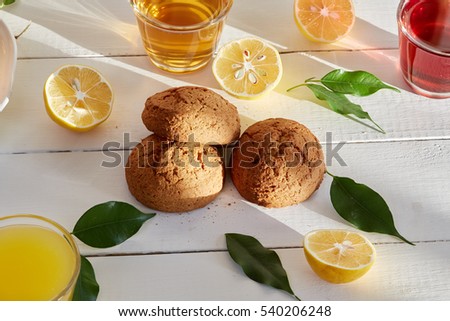 Healthy food & drink & natural diet food: Healthy breakfast. Fruits Juices Citrus fruits & bakery. Apple orange grapes & cherry juices lemon biscuit cake cookie. Top view White wooden table.