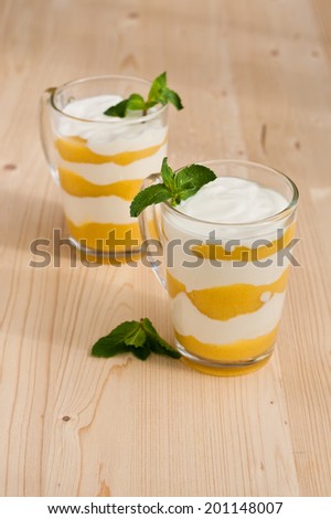 homemade  cream with peach and mint on a wooden background