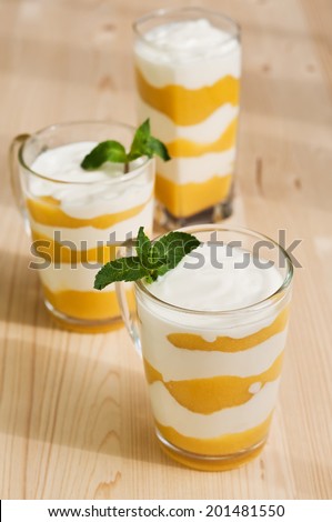 homemade  cream with peach and mint on a wooden background