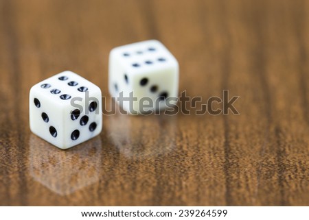 Two dice on a wooden background showing two sixes