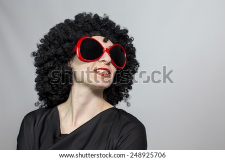 Red lipstic women wearing a black wig with red eyeglasses and posing, isolated copy space background