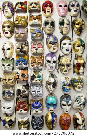 Full of beautiful elegant traditional venetian masks are hanged on wall for street carnival in Venice, Italy