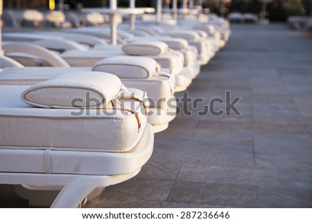 Closeup row of comfortable loungers near the swimming pool at the recreation center