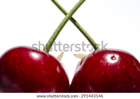 two worms in cherries on white background