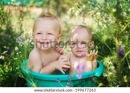 cute kids taking water treatments in the summer garden