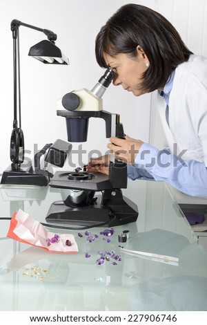 Woman, appraiser gems in laboratory with microscope and gemology instruments