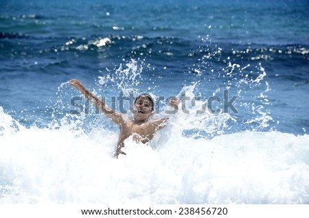 Beach holidays. Water games of the child in the sea waves.