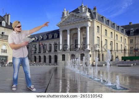 Man with guide book in a hand and classical building in background