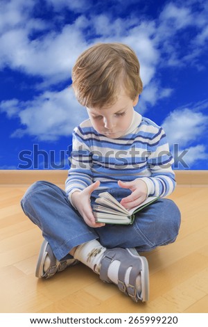 Boy reading book seating on the floor with cloud sky in background