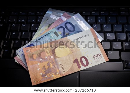 Euro banknotes on laptop keyboard