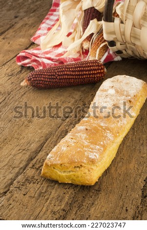 Corn bread and corn cobs on old wooden background