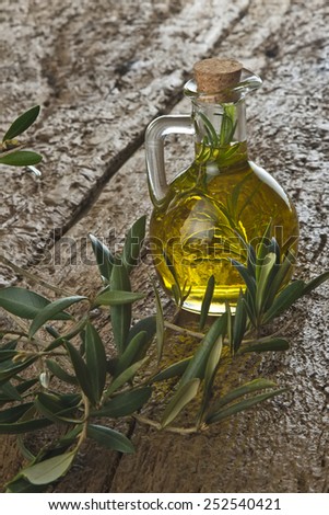 Extra virgin olive oil flavored with fresh rosemary on a old wooden table