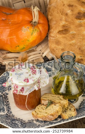 Olive oil, bread, pumpkin and canned tomatoes, on wooden table old style