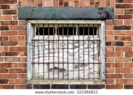 Boarded Window with Metal Bars in an Old Brick Wall