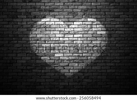 dimly lit old brick wall enlightened cone of light in the shape of heart