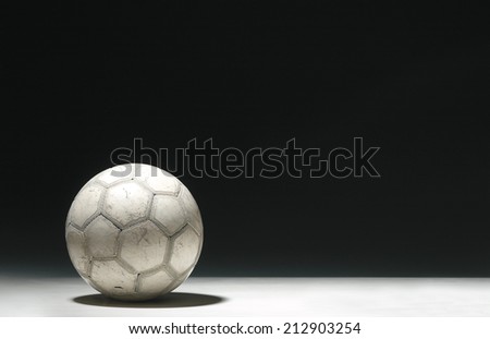 Dirty Old Soccer Ball on a dark Background whit text space.