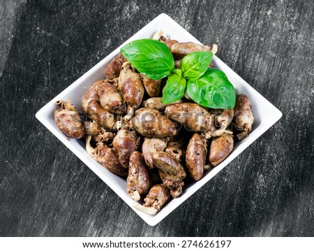 Fresh cooked chicken hearts seasoned with pepper and salt, ready to eat. basil leaf decoration. Background, Texture.