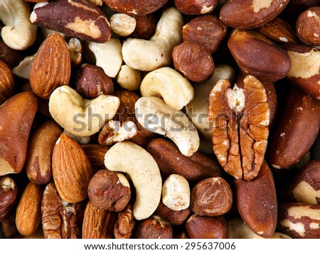Natural background texture made from mixed kinds of nuts - pecans, hazelnuts, walnuts, cashews, almonds, pine nuts, pistachios.