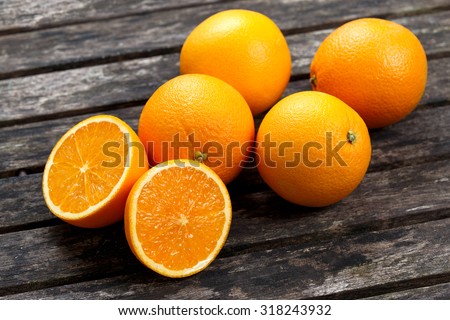 Beautiful Oranges Fruit Full and Sliced on old wooden table. rich with vitamins. background, texture.
