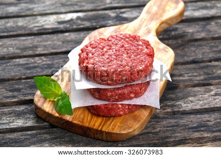 Home HandMade Minced Beef burgers on cutting board. old wooden table