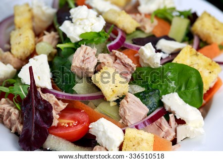 Close up Tuna salad with Spinach, rocket, red ruby chard, tomatoes, cucumbers, carrot, red onion, white chesse, croutons.