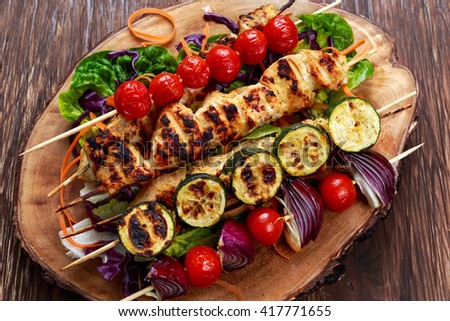 Roast Chicken filet kebab with cherry grilled on BBQ. tomatoes, zucchini and red onions on bamboo sticks.