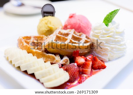 waffles serve with ice cream, strawberry, banana and whipped cream