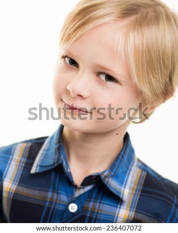 Studio portrait of a blond young boy with blue-grey eyes wearing a smart blue shirt isolated against a white background.