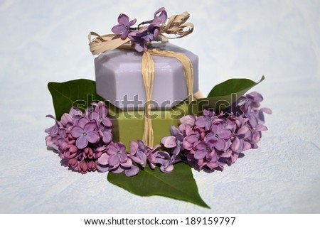 Beauty products .cosmetic  soap with flower extracts. green and blue. gift set. tied with ribbon. with lilac flowers on a blue background .