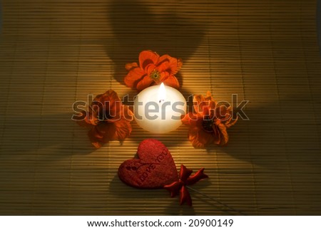 Candle surround by flowers and heart with sign \