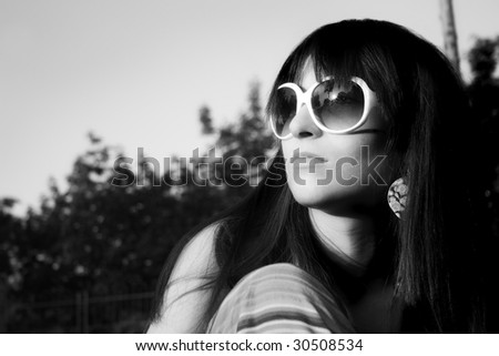 Young modern girl in black-white watch in sun with sunglasses