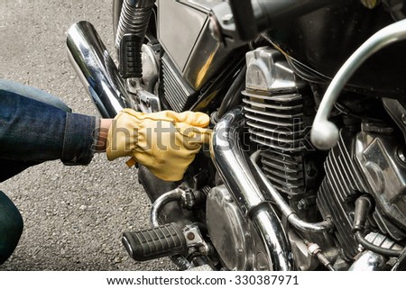 repairing custom motorbike  with a glove , caburator  line   to pipe in the foreground