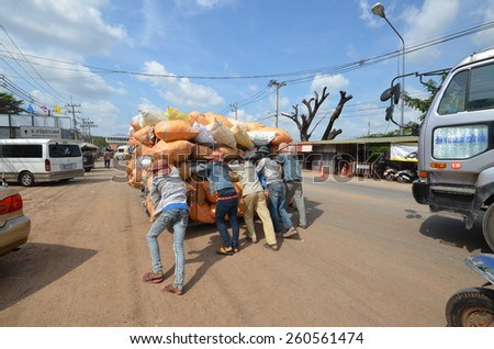 Crowd of young people pushing a cart overloaded bags across the border thailand cambodia.Photo taken on: December 11th, 2012