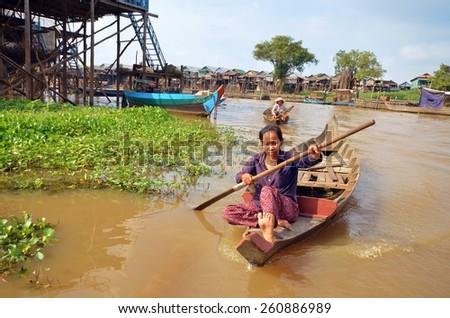 Kampong, Siem Reap, Cambodia 11 December 2012: A woman floating on a boat in the village built on the Tonle Sap lake.  People living on the water in the city of Siem Reap, Cambodia 11/12/2012