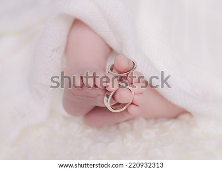 Newborn baby toes with rings on the big toes.