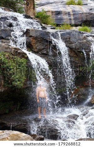 man stand in water fall